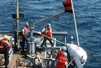 An MSO crew deploys a float, part of an mechanical sweep array, during Persian Gulf oerations.
